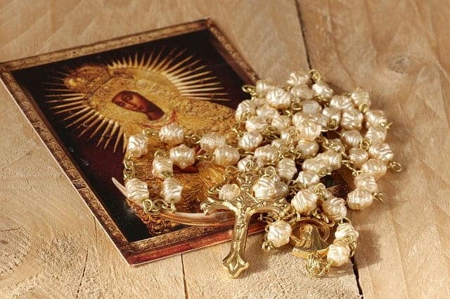 Ein wunderschönes eingerahmtes Bild der Muttergottes Maria sowie ein Rosenkranz mit einem goldenen Kruzifix