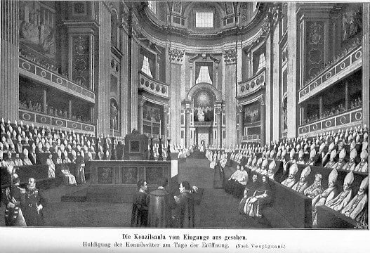 Eröffnung des Vatikanischen Konzils: Die Konzilsaula vom Eingang aus gesehen; rechts und links sitzen die Konzilsväter, im Vordergrund stehen drei Männer in einer Art Besprechung; im Hintergrund sieht man Papst Pius IX. sitzen