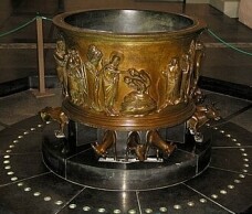 Die Heilsnotwendigkeit der Taufe: Bronze-Taufbecken von Reiner von Huy in St. Barthelémy, Lüttich.